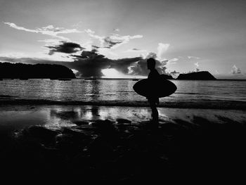 Silhouette woman by sea against sky during sunset