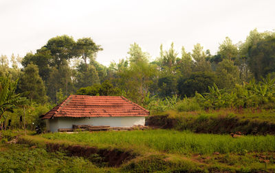 Built structure by trees against sky