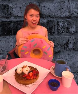 Portrait of smiling young woman sitting on table