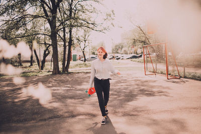 Woman with arms raised in park