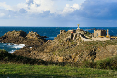 Scenic view of sea by buildings against sky