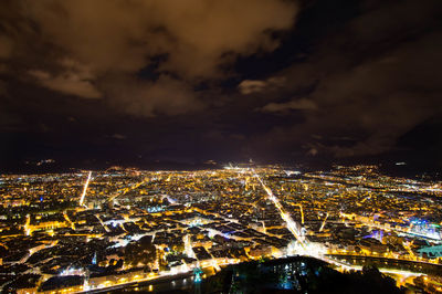 Aerial view of illuminated cityscape against sky at night