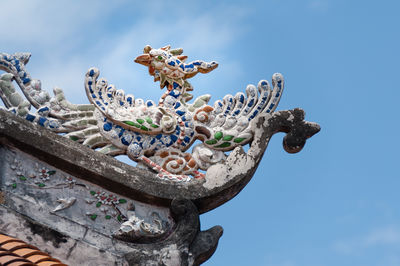 Low angle view of statue against blue sky