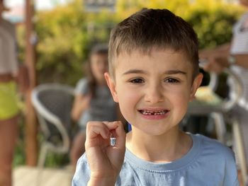 Boy holds a lost tooth.