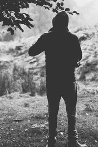Rear view of silhouette man standing outdoors