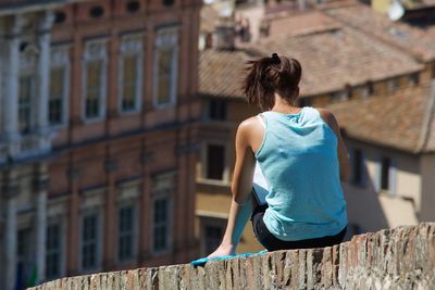 Rear view of woman reading a book outdoors