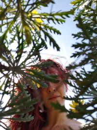 Low angle portrait of woman seen through leaves