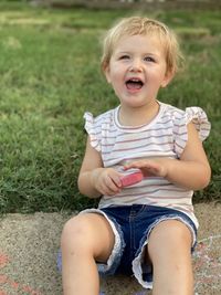 Cute baby girl sitting on field