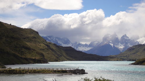 Scenic view of sea and mountains against cloudy sky