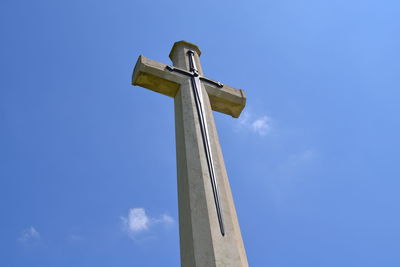 Low angle view of cross on pole against sky