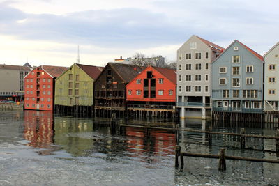 Houses by river against sky