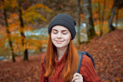 Portrait of smiling young woman in park during autumn