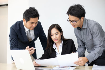 Young couple looking away while standing on paper