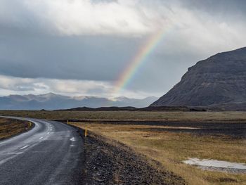 Scenic view of rainbow over mountains against sky