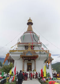 People at temple against sky in city