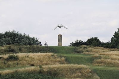 Traditional windmill on field against sky