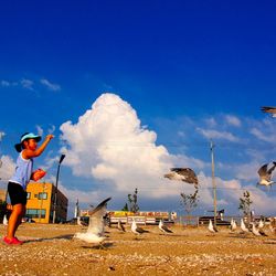 Man standing on field against blue sky