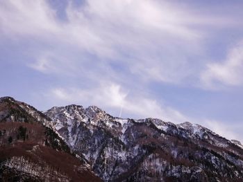 Low angle view of snowcapped mountains against sky