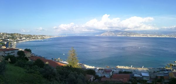 High angle view of city by sea against sky