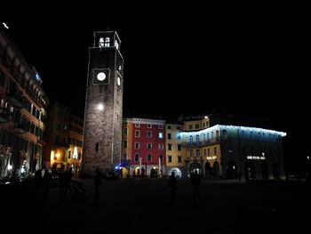 Illuminated clock tower at night