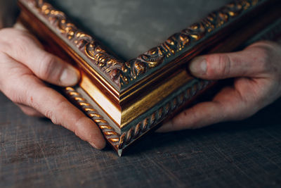 Cropped hand of person holding pocket watch on table