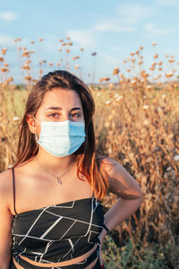 Portrait of serious teenager with a medical mask in the countryside