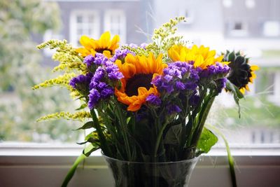 Multi colored bouquet in vase on window sill