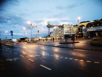 Illuminated city street against sky