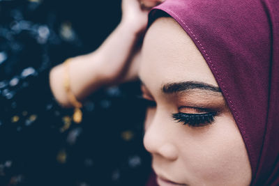 A woman in hijab having a make up done on her wedding day