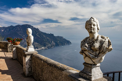 Statue against sky with mountain in background