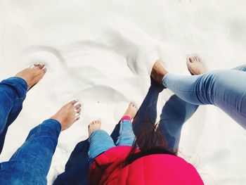 Low section of parents with daughter standing in sand at desert during summer