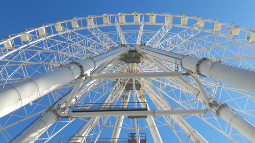 Low angle view of ferris wheel against blue sky