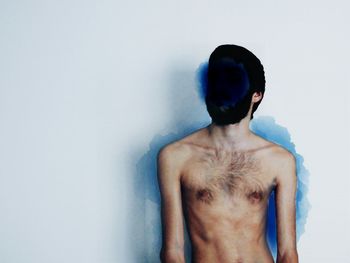 Rear view of shirtless man against white background