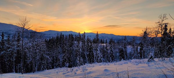 Scenic view of snow covered mountains against sky during sunset