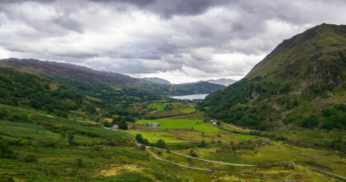 Scenic view of green landscape and mountains against sky