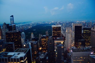 High angle view of illuminated cityscape against cloudy sky