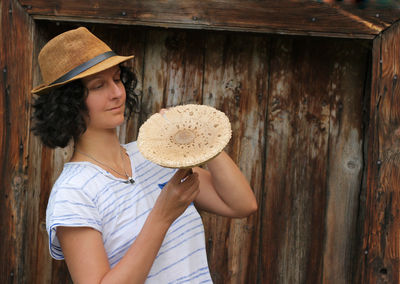 Woman looking away while standing on wood