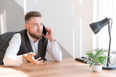 Good news. happy caucasian businessman in shirt talking on phone with client