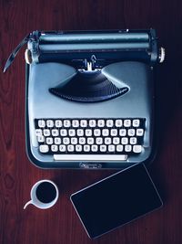 High angle view of typewriter with digital tablet and black coffee on table