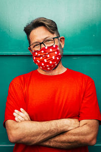 Portrait of man wearing protective mask against wall