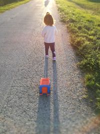 Rear view of toddler girl walking on road