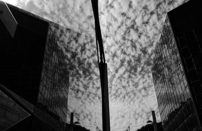 Low angle view of office building against cloudy sky