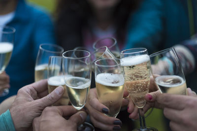 Cropped image of people toasting drinks