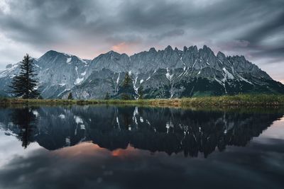 Scenic view of lake by mountains against sky