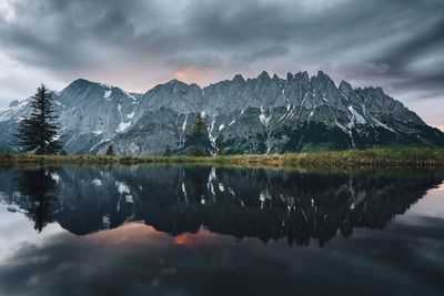 Scenic view of lake by mountains against sky