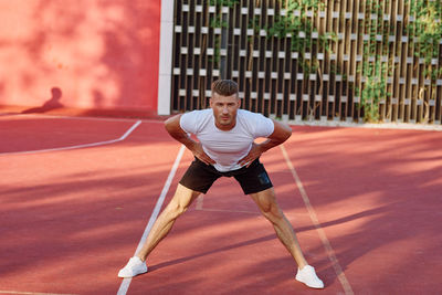 Full length of woman exercising on court