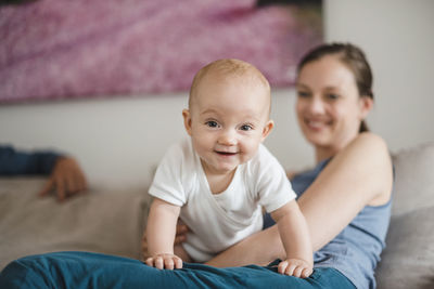 Portrait of smiling boy on bed at home