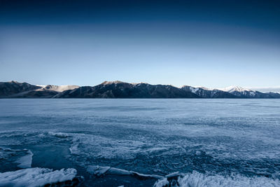 Scenic view of snowcapped mountains against blue sky