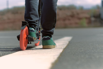 Low section of man skateboarding on road