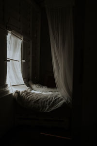 White curtain hanging on bed at home
